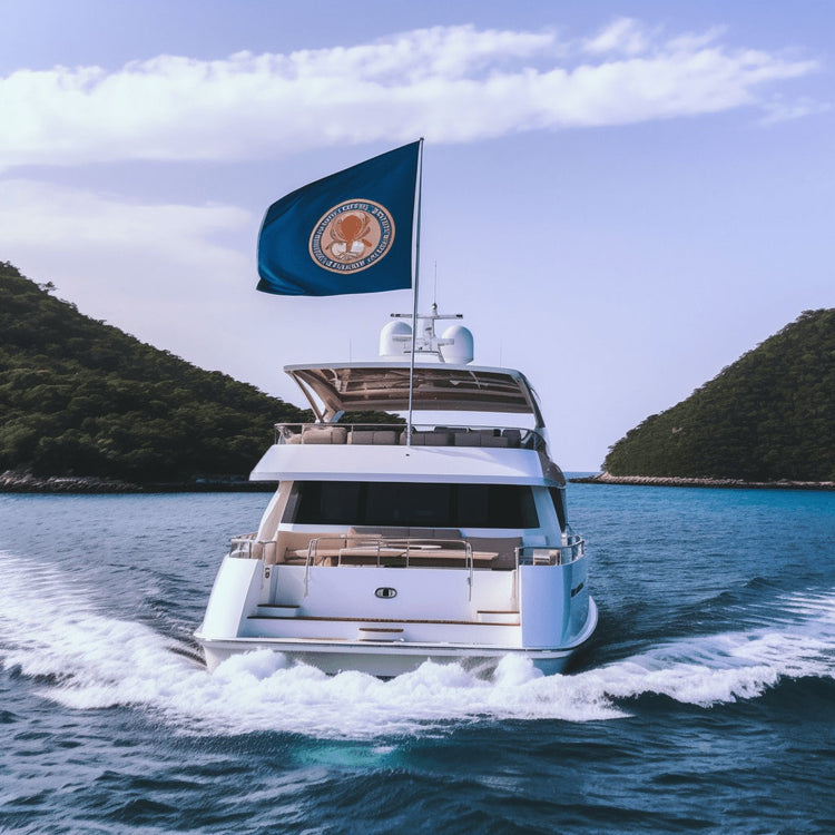 A yacht sailing to a tropical island with a custom flag flying off the back of it.